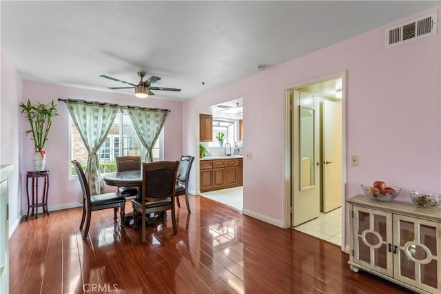 dining area featuring a wealth of natural light, a ceiling fan, visible vents, and wood finished floors
