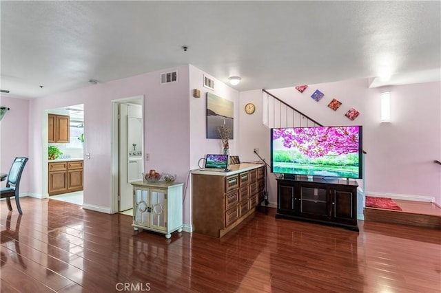 living area with plenty of natural light, dark wood-type flooring, baseboards, and visible vents