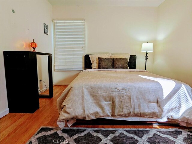 bedroom with baseboards and wood finished floors