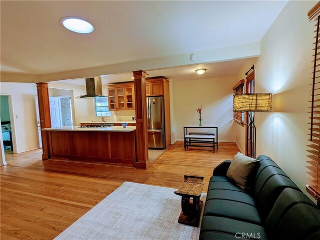 living room with ornate columns and light wood-style flooring