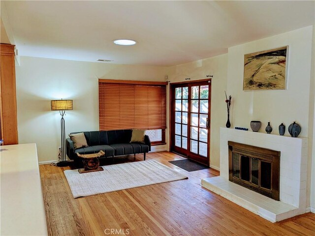 living area with baseboards, visible vents, and wood finished floors