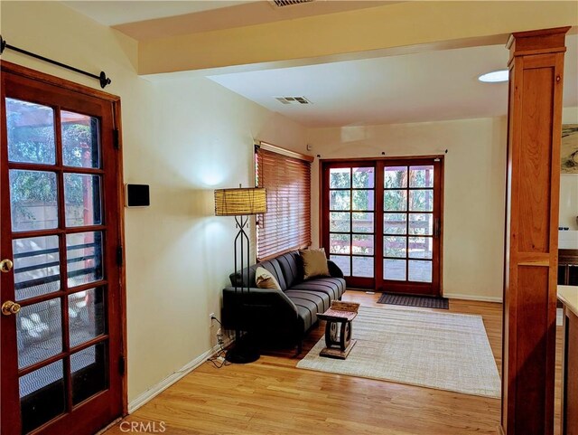 living area with visible vents, light wood finished floors, and baseboards