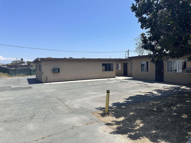 back of property featuring stucco siding and fence