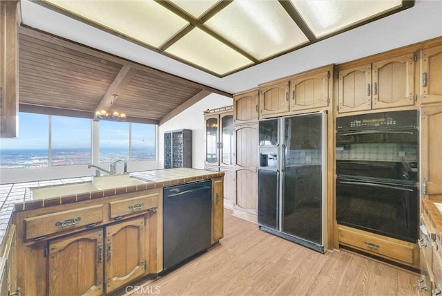 30062 Grandpoint Ln, Rancho Palos Verdes, CA 90275 - kitchen with black appliances, tile counters, light wood finished floors, and brown cabinetry