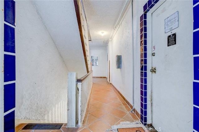 hall featuring a textured ceiling and tile patterned floors