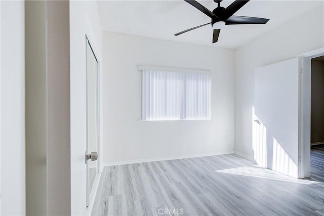 spare room featuring baseboards, a ceiling fan, and wood finished floors