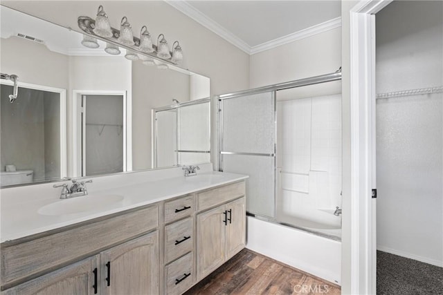 15427 Park Point Ave Unit 110, Lake Elsinore, CA 92532 - bathroom featuring ornamental molding, double vanity, a spacious closet, combined bath / shower with glass door, and wood finished floors