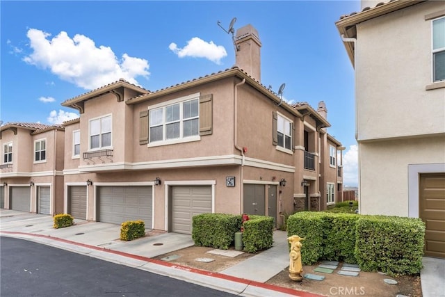 15427 Park Point Ave Unit 110, Lake Elsinore, CA 92532 - view of front of home with a chimney, stucco siding, and a garage