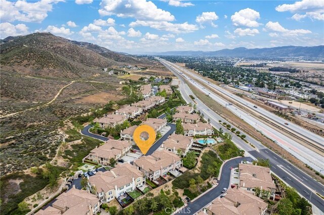 15427 Park Point Ave Unit 110, Lake Elsinore, CA 92532 - aerial view of property's location with a highway, a mountain backdrop, and nearby suburban area