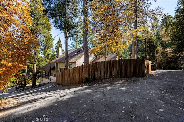 view of property exterior featuring fence and a chimney