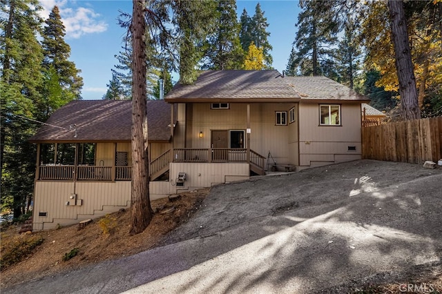 view of front of house featuring crawl space, fence, and roof with shingles