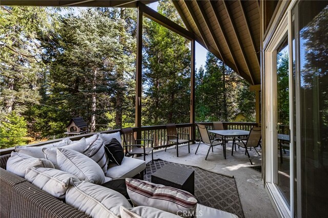 sunroom / solarium featuring outdoor dining space, an outdoor living space, and a healthy amount of sunlight