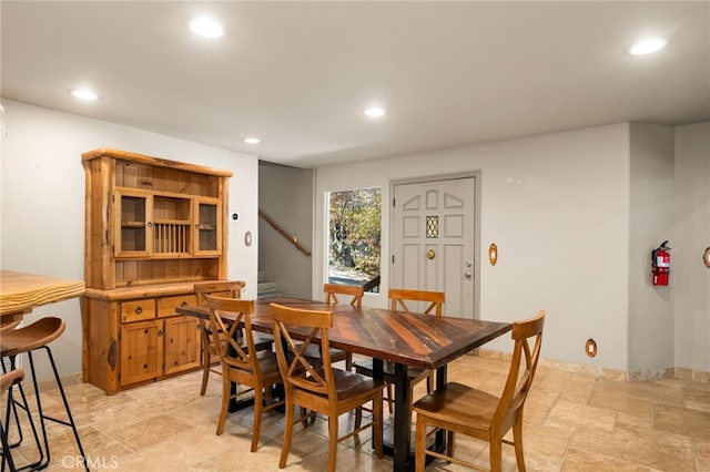 dining space with stairway, recessed lighting, and stone tile floors