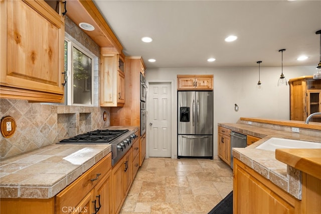 kitchen featuring stone tile floors, recessed lighting, a sink, backsplash, and stainless steel appliances