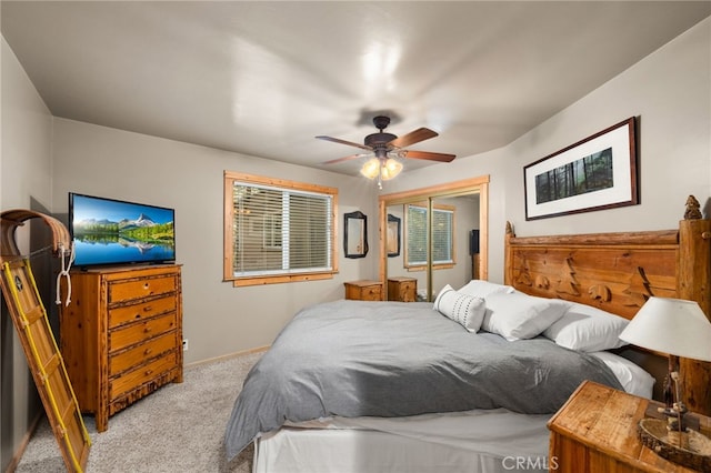 bedroom featuring ceiling fan, light colored carpet, baseboards, and a closet