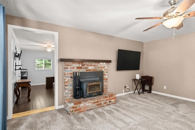 9137 Midway, Durham, CA 95938 - living room featuring baseboards, a wood stove, ceiling fan, and carpet flooring