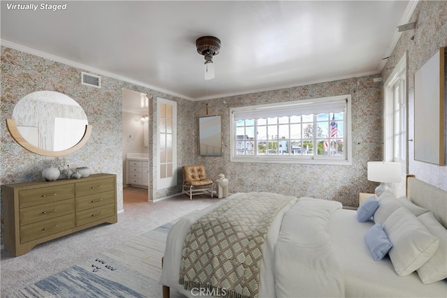 bedroom featuring light carpet, ensuite bath, wallpapered walls, visible vents, and ornamental molding