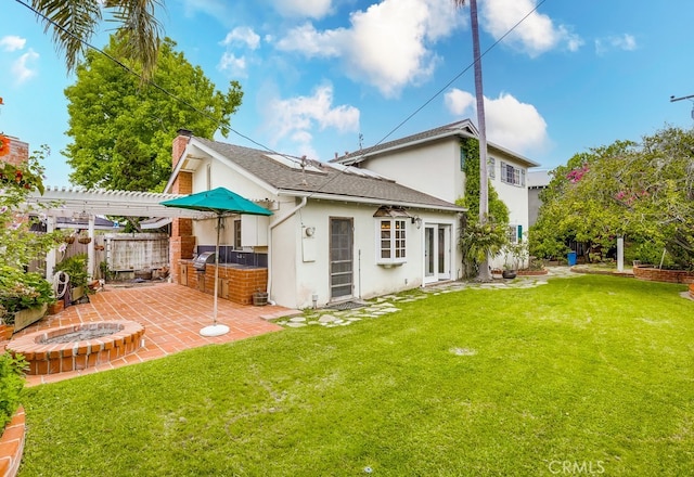 back of house with fence, stucco siding, area for grilling, a patio area, and a yard