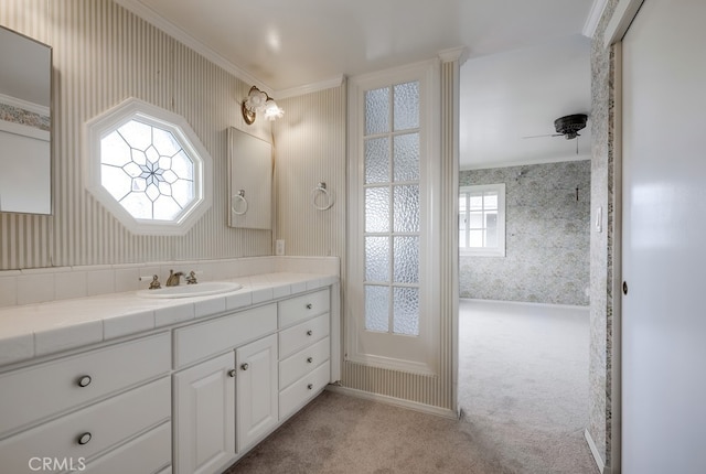 bathroom with vanity, ornamental molding, a ceiling fan, and wallpapered walls