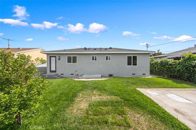 rear view of property featuring a yard, crawl space, entry steps, and stucco siding