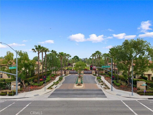 view of road featuring street lighting, curbs, and sidewalks