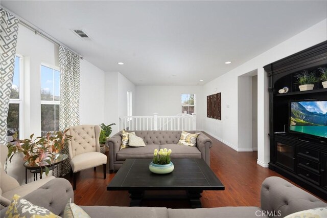 living room with baseboards, recessed lighting, wood finished floors, and visible vents
