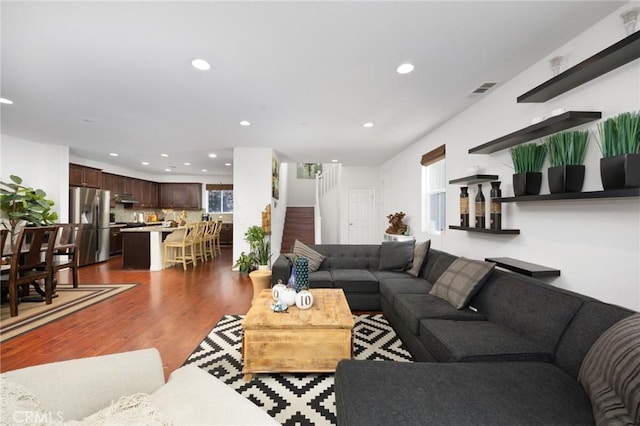 living area featuring recessed lighting, dark wood-style floors, stairway, and visible vents