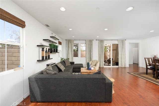 living room with recessed lighting, visible vents, and wood finished floors