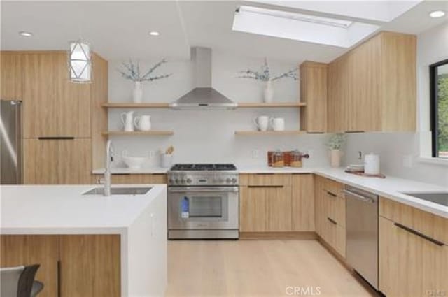 kitchen with open shelves, light brown cabinets, modern cabinets, wall chimney range hood, and stainless steel appliances