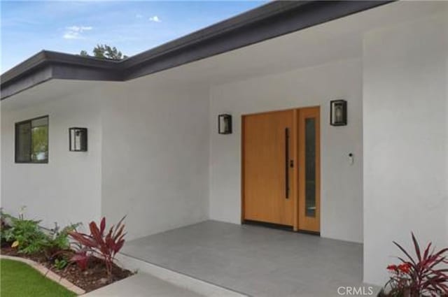 property entrance with stucco siding
