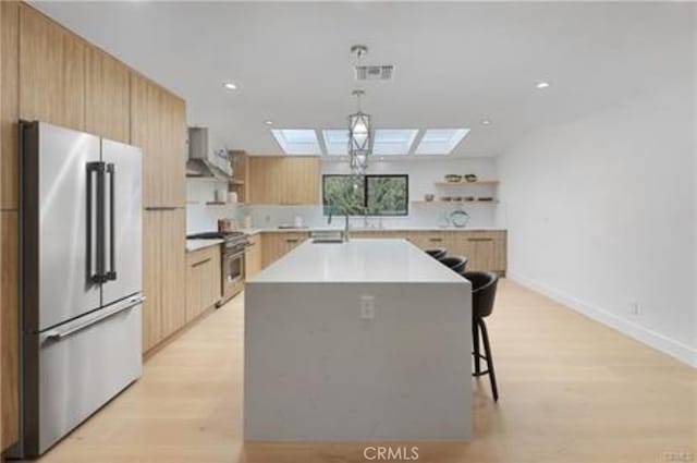 kitchen with premium appliances, extractor fan, a skylight, and open shelves