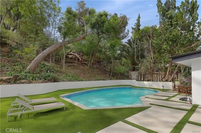 outdoor pool featuring a yard and a patio