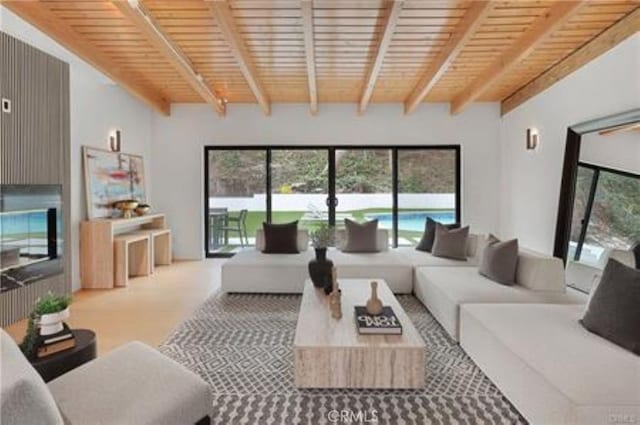 living area featuring a wealth of natural light, wooden ceiling, and beamed ceiling