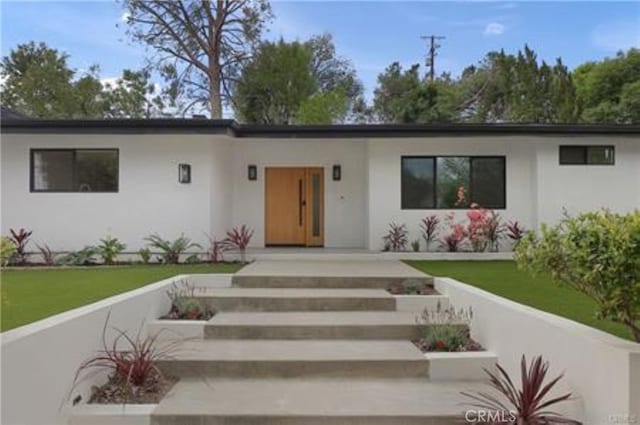 view of front of property with a front yard and stucco siding