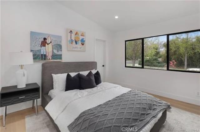 bedroom with recessed lighting, baseboards, and wood finished floors