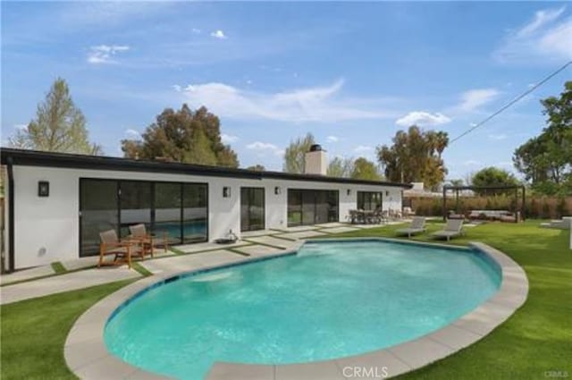 pool featuring a patio area and a yard