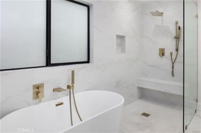 full bathroom with a freestanding bath and a marble finish shower