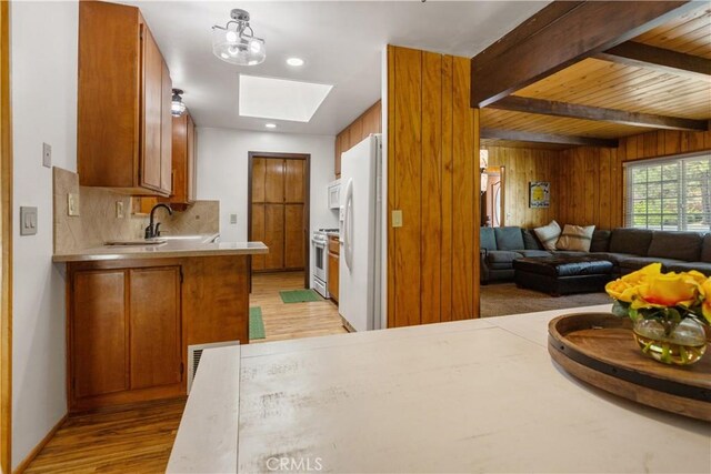 kitchen featuring white appliances, light wood-type flooring, light countertops, brown cabinets, and backsplash