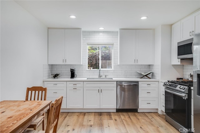 129 Avenida Rosa, San Clemente, CA 92672 - kitchen featuring decorative backsplash, light countertops, white cabinetry, a sink, and appliances with stainless steel finishes