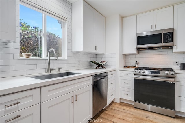 129 Avenida Rosa, San Clemente, CA 92672 - kitchen with white cabinets, appliances with stainless steel finishes, a sink, and tasteful backsplash
