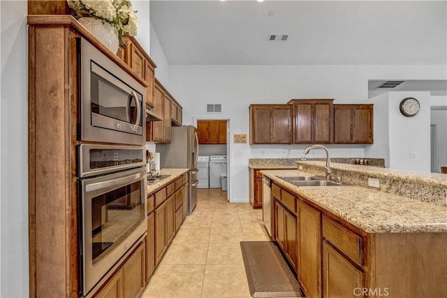 kitchen with visible vents, a sink, washing machine and dryer, and stainless steel appliances