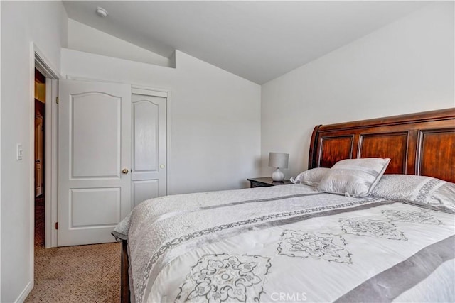 bedroom with light colored carpet, lofted ceiling, and a closet