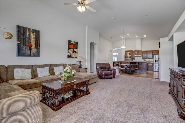 living area with carpet flooring, ceiling fan, high vaulted ceiling, recessed lighting, and arched walkways