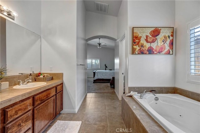 full bath featuring visible vents, vanity, a jetted tub, ceiling fan, and ensuite bath