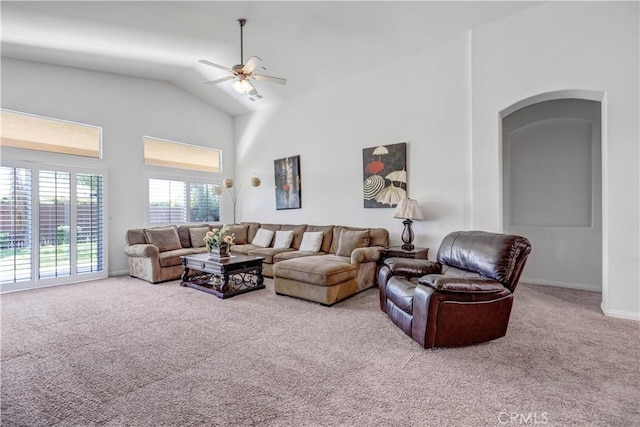 living room featuring carpet floors, baseboards, high vaulted ceiling, arched walkways, and a ceiling fan