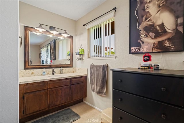 bathroom featuring baseboards, plenty of natural light, and vanity