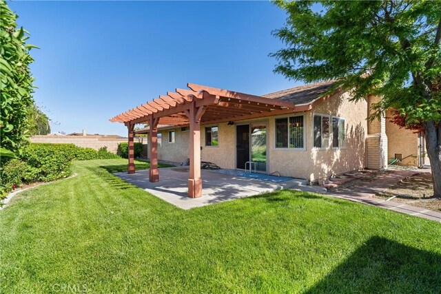 back of house featuring fence, a pergola, a patio, stucco siding, and a lawn