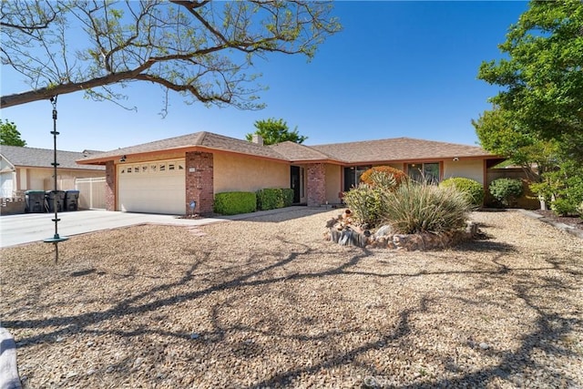 ranch-style home featuring a garage, concrete driveway, and brick siding