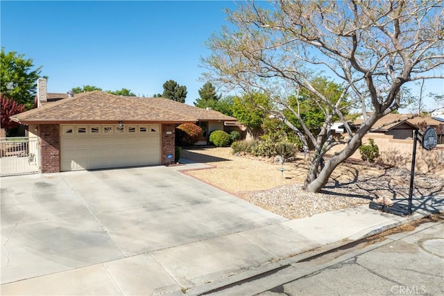 single story home featuring brick siding, an attached garage, driveway, and a chimney