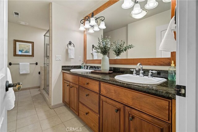 full bathroom featuring double vanity, tile patterned floors, a sink, and a stall shower